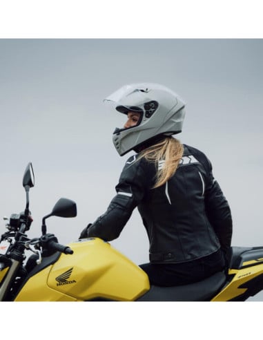 Coureuse à moto en casque intégral blanc sur une moto jaune Honda