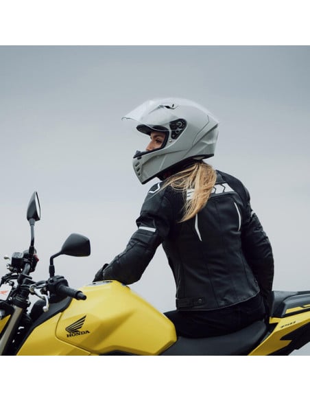 Moto-cycliste portant casque Airoh Conor sur une moto jaune Honda, vue de côté.